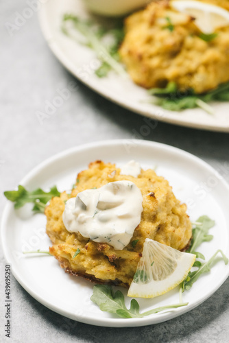 Crabcake topped with remoulade and lemon photo