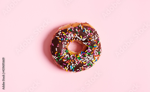 One Choclolate Sprinkle Donut on Pink Background  photo