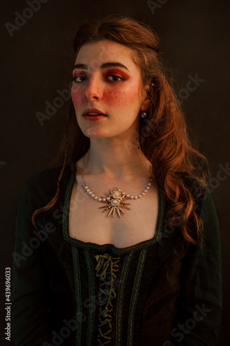 Girl medieval portrait red green tones long hair looking at the camera  photo
