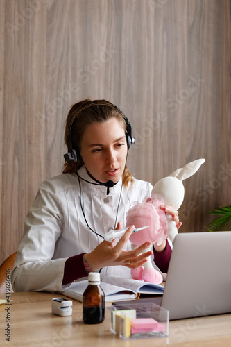 Doctor having telemedicine consultation via laptop at home photo