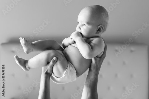 Man hands holding a baby in the air photo