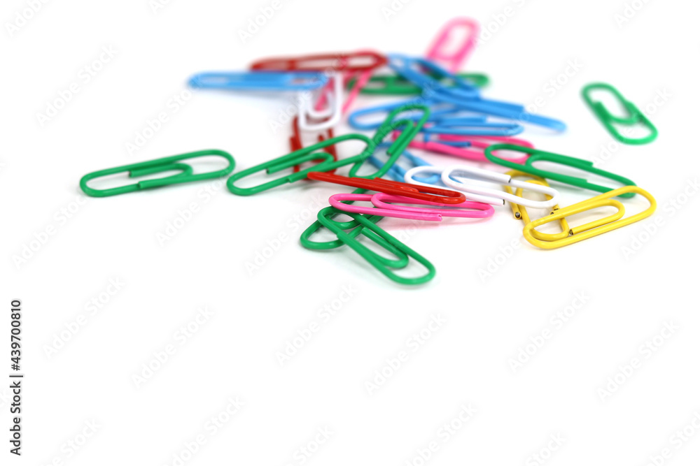 colored paper clips scattered on a white background colored paper clips scattered on a white background