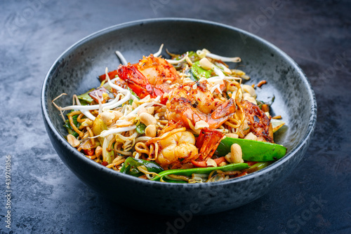 Modern style traditional Thai phak kung curry with barbecue king prawns and noodles as close-up in Nordic design bowl with copy space