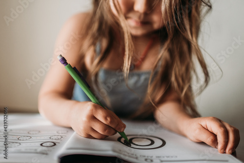 Close up detailed image of anonymous little girl learning at home  photo