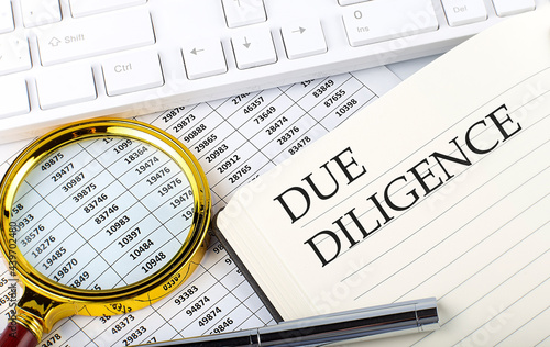 DUE DILIGENCE text on notebook with chart, magnifier,keyboard and pen