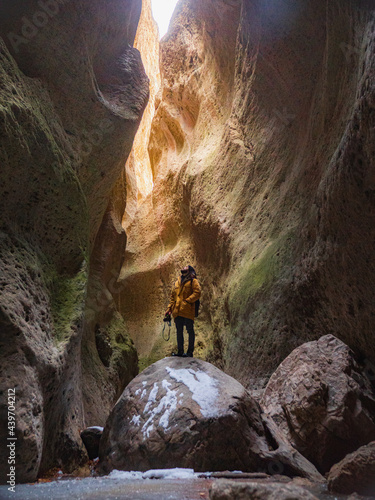 Traveler inside a massive mountain gorge
 photo