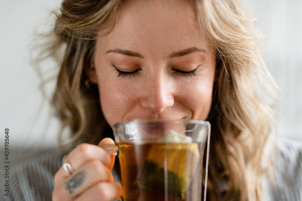 Relaxed Woman Smells a Cup of Steeping Tea Relaxed Woman Smells a Cup of Steeping Tea