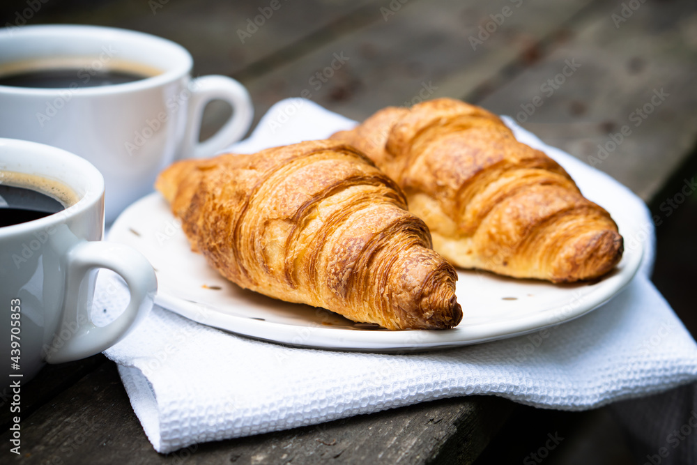 Coffee and croissants on old rustic wooden table