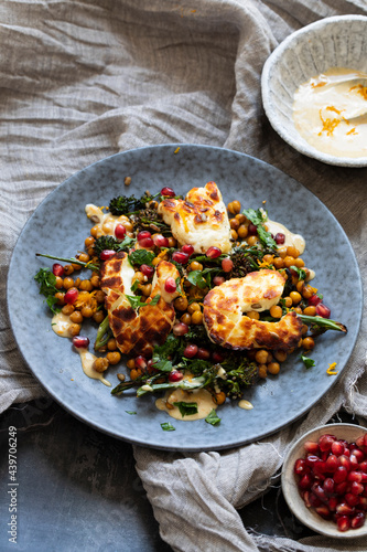Grilled halloumi cheese with roasted chickpeas, broccollini, tahini sauce and pomegranate