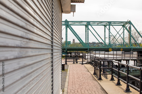 Pont en métal vert en arrière plan et espace piéton en avant plan avec mur en métal linéaire photo