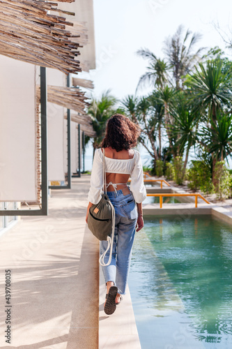 Pretty summer woman tourist style walking in luxury resort  photo