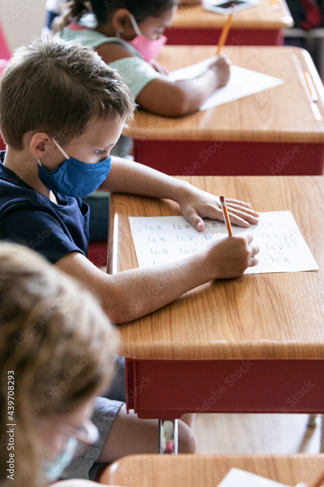 School: Student With Face Mask Works On Math Sheet School: Student With Face Mask Works On Math Sheet