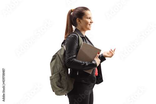 Teenage female with a backapck and book gesturing with hand photo