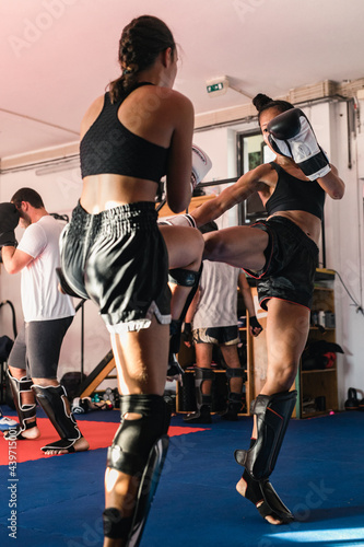 Thai Female Muay Thai Athlete Kicking The Opponent photo