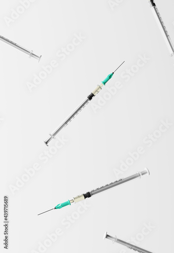 Syringes falling against white background