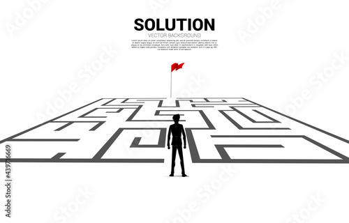 Silhouette of businessman enter to maze to red flag. business concept for finding solution and reach goal