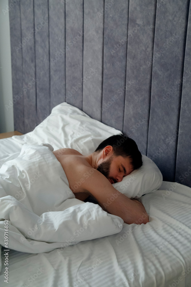 Shirtless man sleeping on comfy bed in morning Shirtless man sleeping on comfy bed in morning