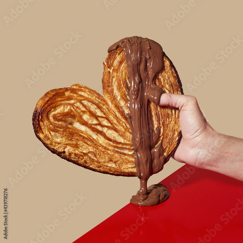 man with a heart-shaped pastry in his hand photo