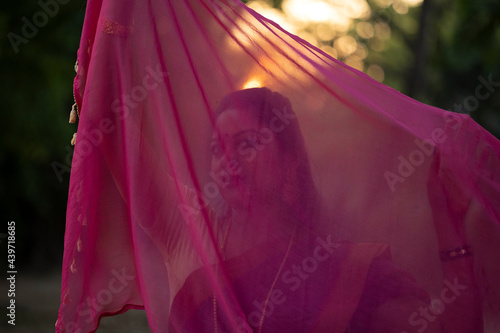 Indian woman making fun with pink colored cloth at outdoors photo