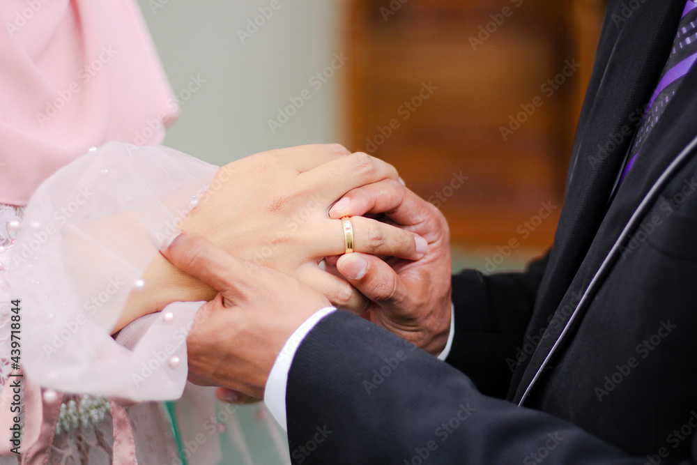 Close up a man places wedding ring on a woman