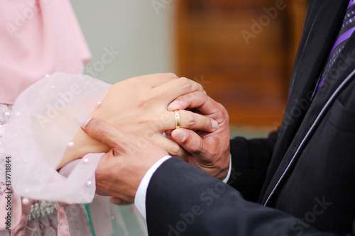 Close up a man places wedding ring on a woman © Yusuf