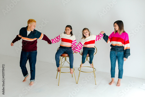 Two moms and daughters in sweaters