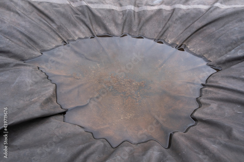 Pool of rainwater on grey tarp