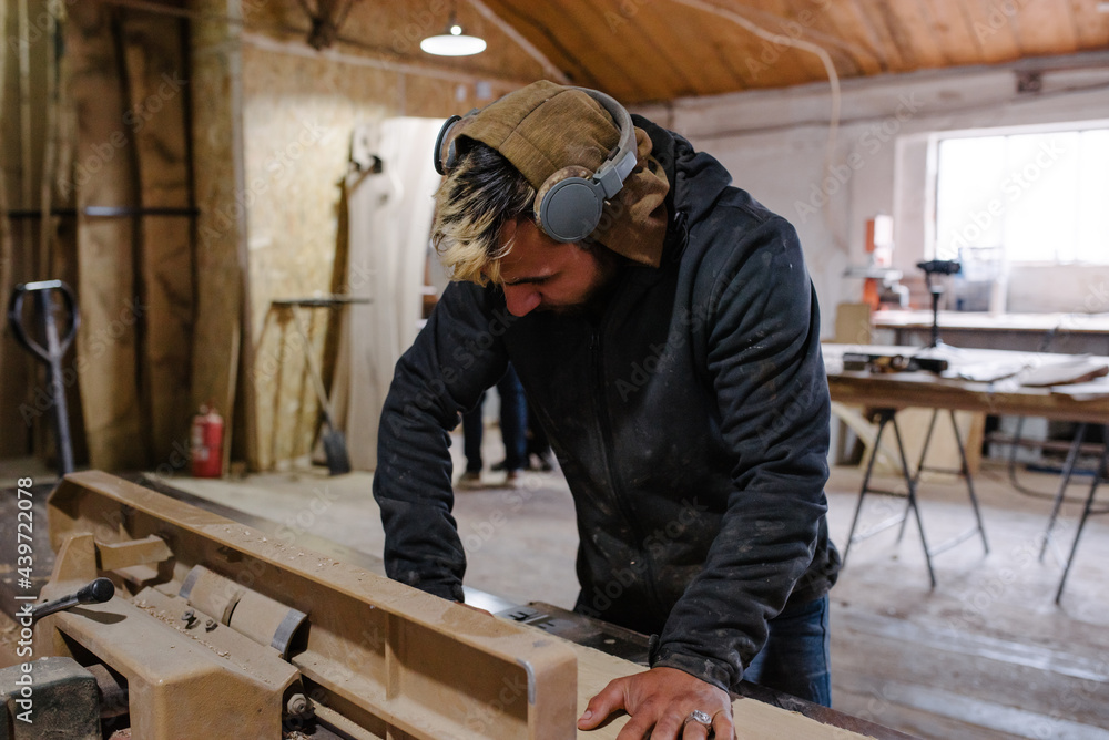 Worker cutting wood on a table saw Worker cutting wood on a table saw