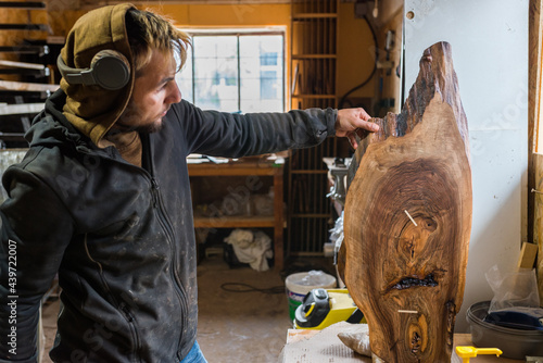 Woodworker looking at a piece of wood he finished