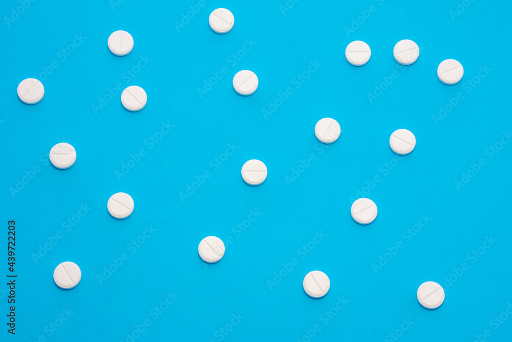 Background for pharmacy or medicine. White pills with medicine are on a blue uniform background, forming a polka dot pattern Background for pharmacy or medicine. White pills with medicine are on a blue uniform background, forming a polka dot pattern