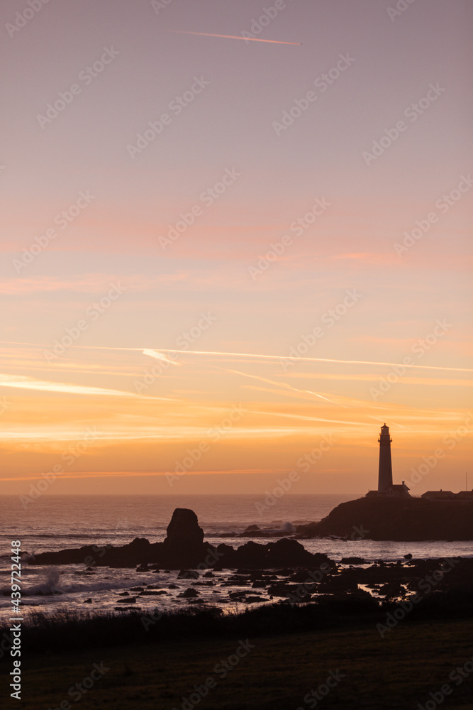 Lighthouse at sunset against an orange sky Lighthouse at sunset against an orange sky