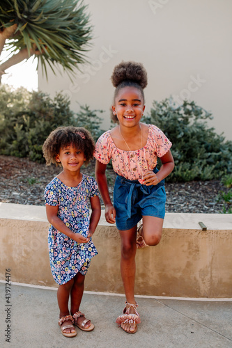 Black sisters standing together outdoors photo