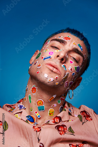 Determined man with stickers on face looking at camera photo
