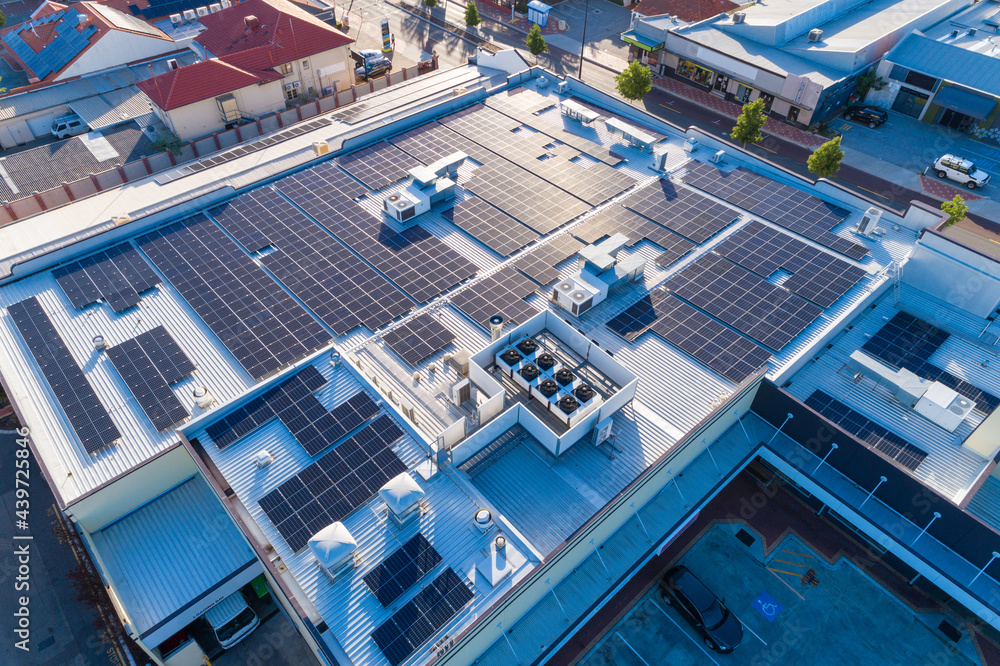 Aerial views over commercial building with over 600 solar panels installed Aerial views over commercial building with over 600 solar panels installed