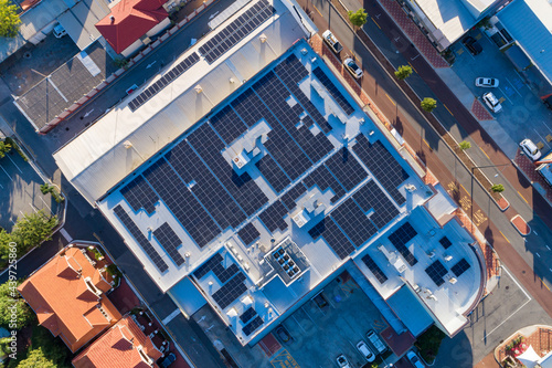 Aerial views over commercial building with over 600 solar panels installed photo