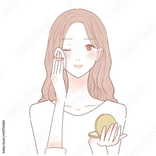 パウダリーファンデーションをパフで顔に塗る女性