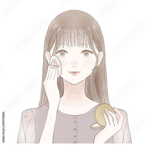 パウダリーファンデーションをパフで顔に塗る女性
