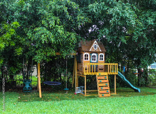 Backyard wooden swing set for kids to play. Summer time activity photo