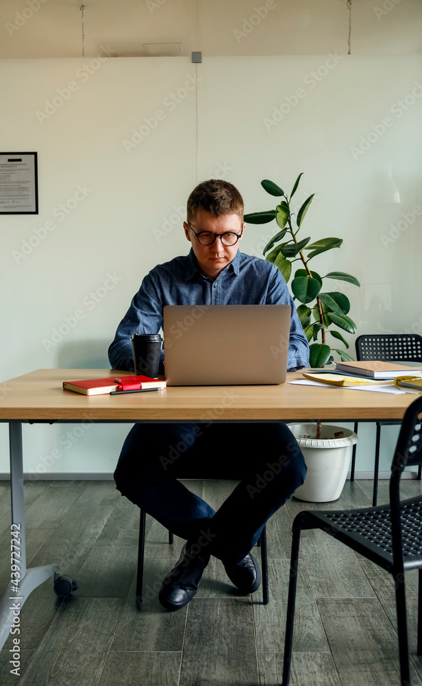 Focused man working on laptop in office Focused man working on laptop in office