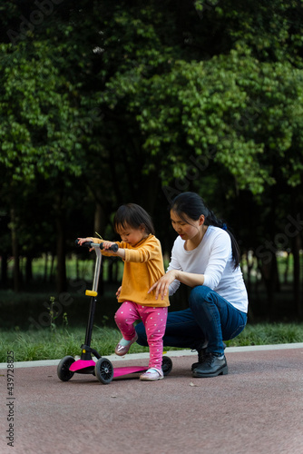 asian kid learning scooter in the park photo