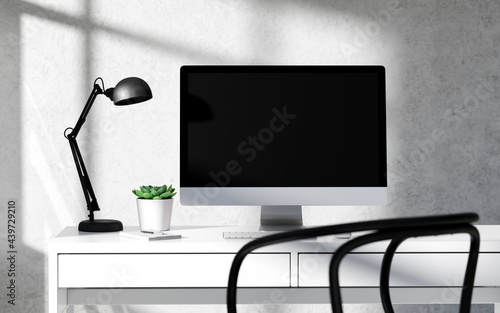 Minimalist workspace with computer on white table