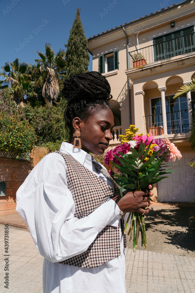 © Lucas Ottone/Stocksy - Woman holding a flower bouquet