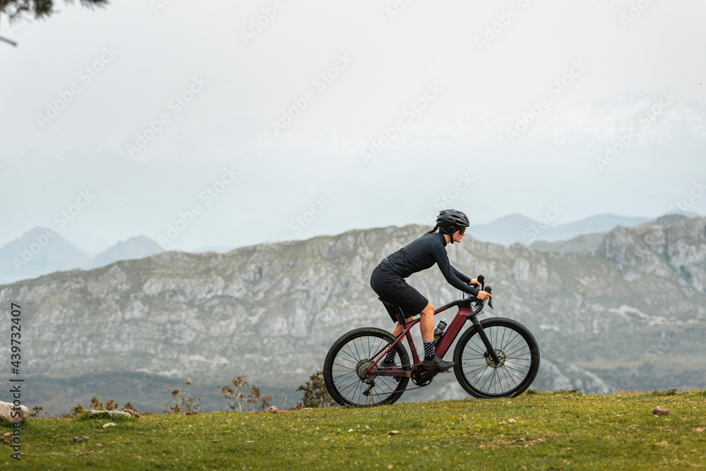 Sportive bicyclist working out on e bike in mountains Sportive bicyclist working out on e bike in mountains