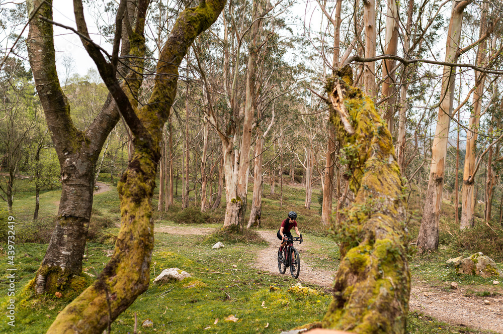 Determined woman cycling uphill on electric bike Determined woman cycling uphill on electric bike