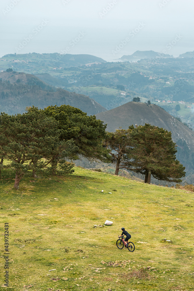Active woman cyclist riding bike on hillside Active woman cyclist riding bike on hillside