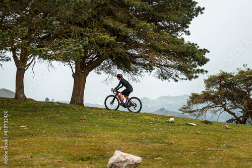 Cyclist riding e bike at forested mountains 