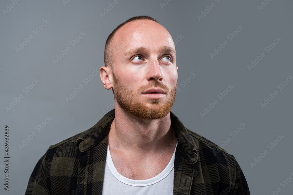 Obraz premium Studio shot of young man looking up. Handsome guy with confident face.
