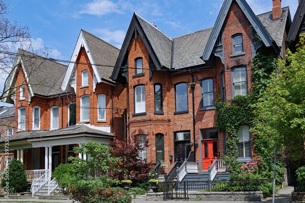 Row of old Victorian semi-detached houses with gables, typical of older neighborhoods in downtown Toronto