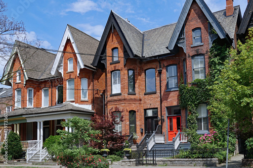 Row of old Victorian semi-detached houses with gables, typical of older neighborhoods in downtown Toronto © Spiroview Inc.