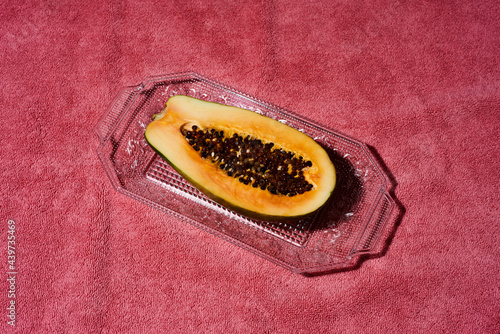 halved papaya fruit in a glass tray photo